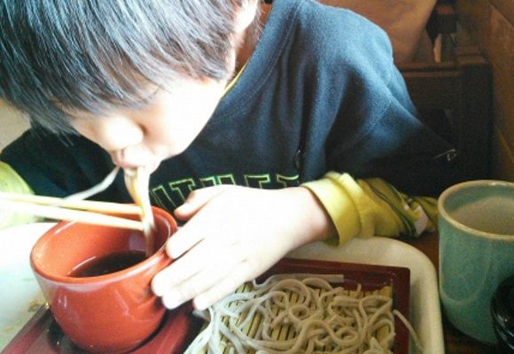 ずーずーと音を立ててそばをすする男の子