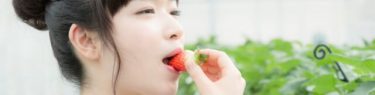ぱくんとイチゴを食べる女性