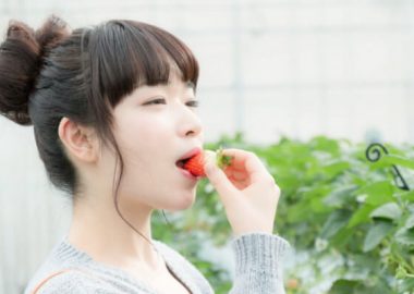 ぱくんとイチゴを食べる女性