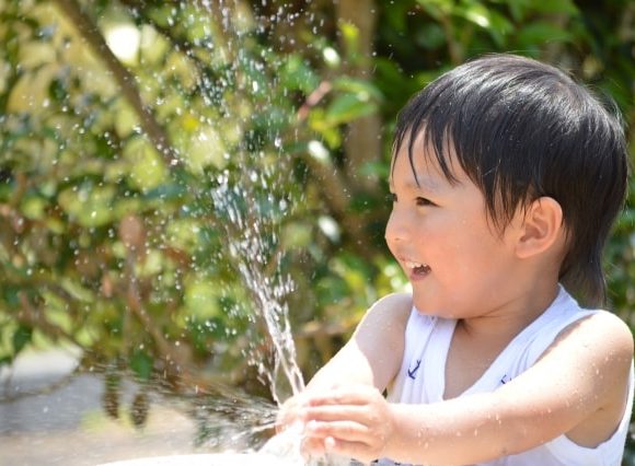 じゃっと水遊びをする男の子