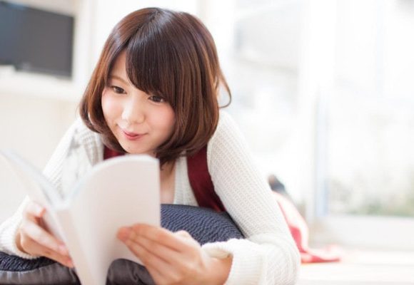 本を読みくすりと笑う女性