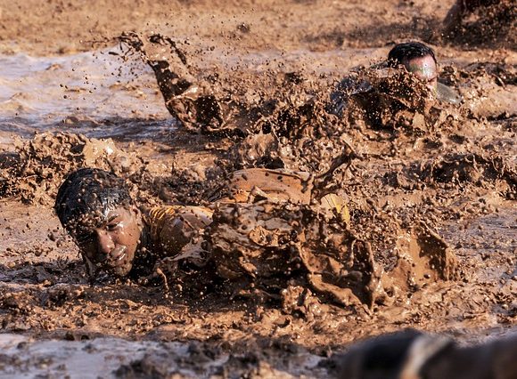 ずぼんと泥に浸かる男性