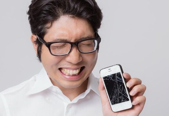 スマホにヒビが入りくーっと声を上げる男性