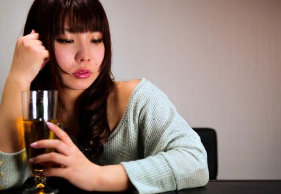 ぐでんとお酒に酔う女性